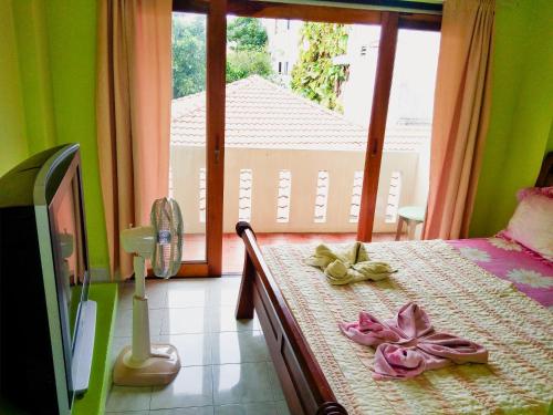 - une chambre avec un lit et une grande fenêtre dans l'établissement Pott Guesthouse, à Chaweng