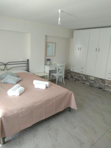 a bedroom with a bed and a table and cabinets at Vassiliki Limnos in Áyios Dhimítrios