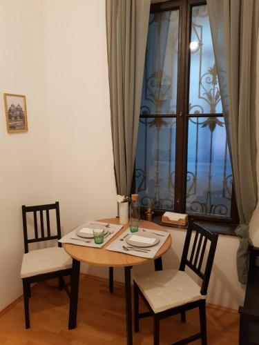 a dining room table with two chairs and a window at Sweet flat in the center of vienna in Vienna