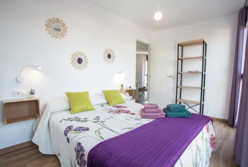 ein Schlafzimmer mit einem Bett mit einer lila Decke in der Unterkunft Los Palomitos, Casco Histórico VT-47255-V in Gandía