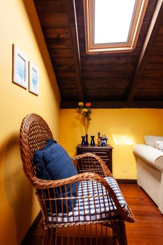 a wicker chair with a blue pillow in a room at Chalet Pico das Pedras in Santana