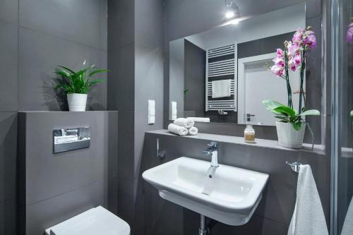 グディニャにあるSleepy3city Apartments Batorego 9 IIのバスルーム(洗面台、トイレ、鏡付)