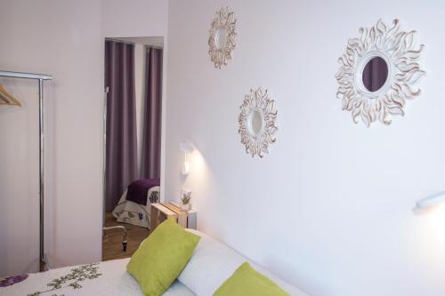 a bedroom with a bed and two mirrors on the wall at Los Palomitos, Casco Histórico VT-47255-V in Gandía