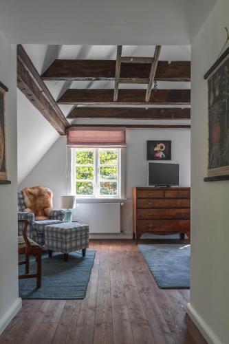 a living room with a couch and a tv at meinsachsenwald forsthaus friedrichsruh in Aumühle