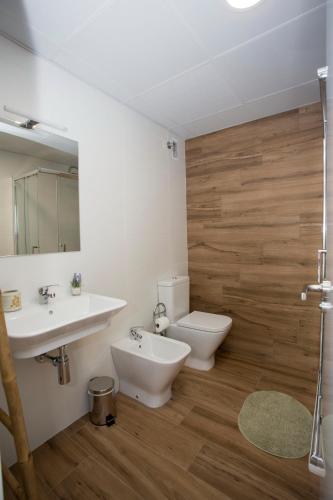 a bathroom with a sink and a toilet and a mirror at Los Palomitos, Casco Histórico VT-47255-V in Gandía