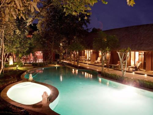 a swimming pool at night in a resort at The Menjangan by LifestyleRetreats in Banyuwedang