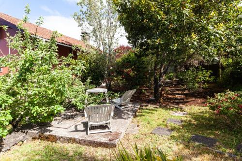 a patio with a chair and a table in a yard at Chalet Pico das Pedras in Santana