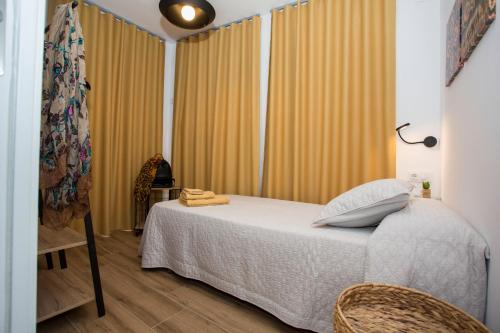 a bedroom with a bed and a window with curtains at Los Palomitos, Casco Histórico VT-47255-V in Gandía
