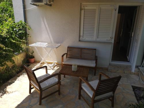 two chairs and a bench sitting on a patio at Apartments Milevčić in Jelsa