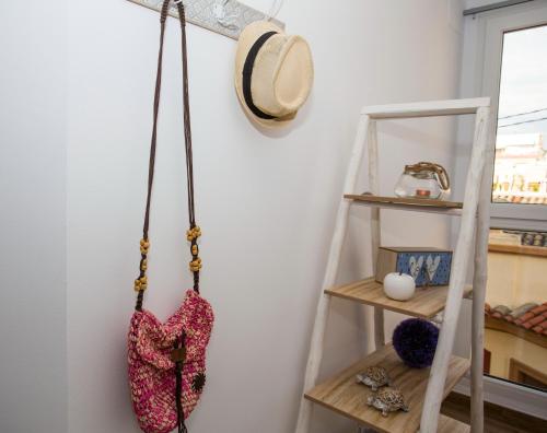 a shelf with a hat and a purse hanging on a wall at Los Palomitos, Casco Histórico VT-47255-V in Gandía