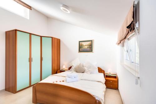 een slaapkamer met een groot bed met witte muren bij Croatica Suites Podsolarsko in Šibenik