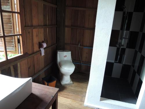 a bathroom with a toilet in a wooden wall at Arun Mekong Guesthouse in Kratie