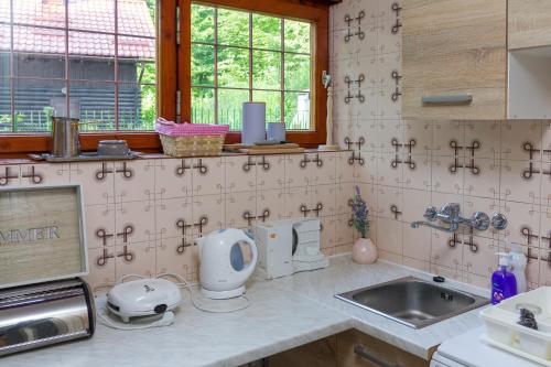 a tiled kitchen with a sink and a counter top at Samobor holiday villa - Samoborski ljetnikovac in Samobor