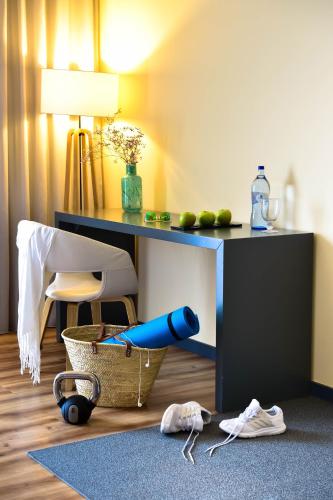モンテ・ゴルドにあるThe Prime Energize Hotel & SPA - Algarveのデスク、椅子、テーブルが備わる客室です。
