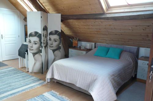 a bedroom with a bed with posters of women at le Petit Papillon in Eymoutiers
