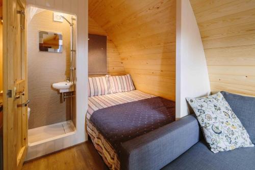 een kleine kamer met een bed in een tiny house bij Buttercup Glamping Pod in Cheltenham