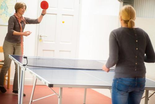 two women playing a game of table tennis at Buttercup Glamping Pod in Cheltenham