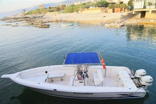 a white boat with a blue roof on the water at Cimer SafraMarine Beach Resort in Safra