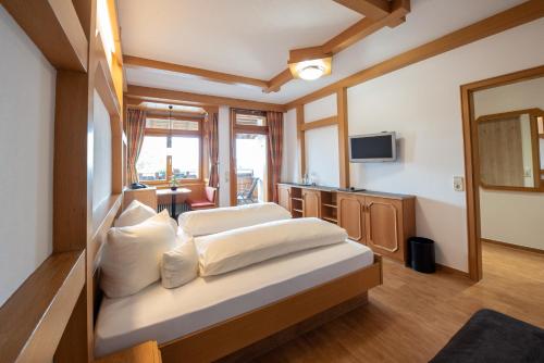 a hotel room with two beds and a television at Wellnesshotel Sonnenhof & Sonnhalde in Ühlingen-Birkendorf