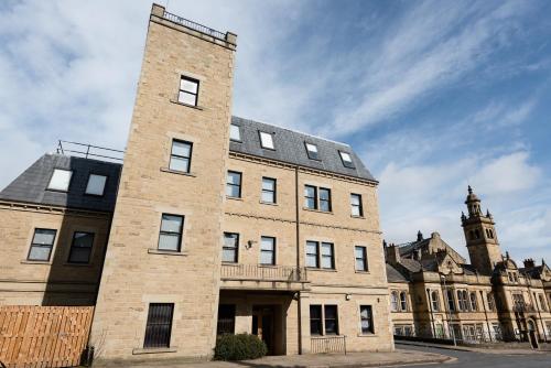 a large brick building with a clock tower in the background at Halifax House, Studio Apartment 214 in Halifax