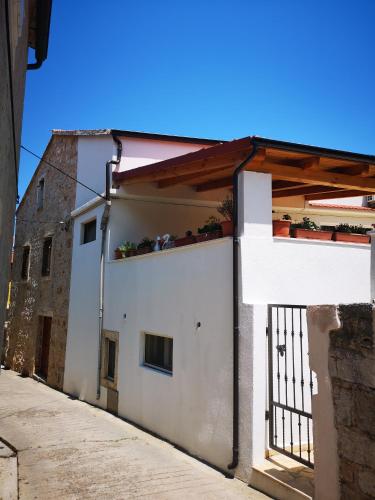 a white building with a balcony with plants on it at Apartments Milevčić in Jelsa