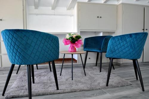 two blue chairs and a table with a vase of flowers at Ibanova Appartements in Collioure
