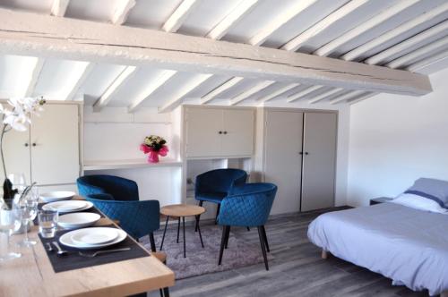 um quarto com uma cama, uma mesa e cadeiras em Ibanova Appartements em Collioure