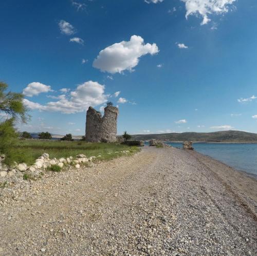 an old castle on the shore of a body of water at Seline Summer Home in Seline