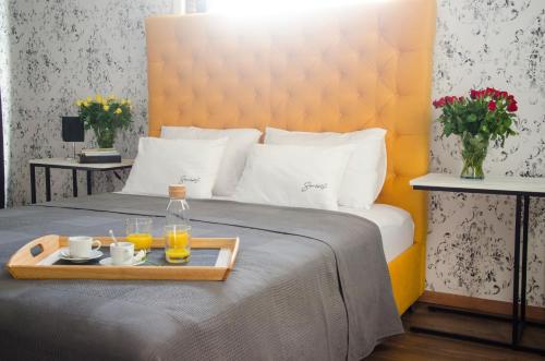 Bett mit einem Tablett mit 2 Gläsern Orangensaft in der Unterkunft Serendipity in Smederevo