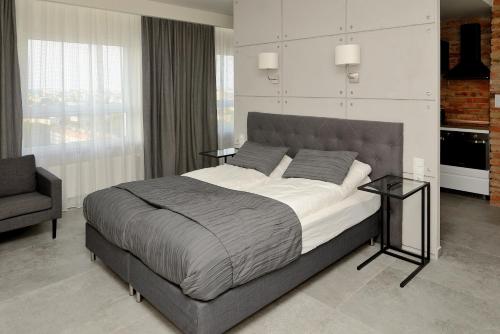 a bedroom with a large bed and a chair at Bułgarska 59A- (1/2) piękny widok 14 piętro in Poznań