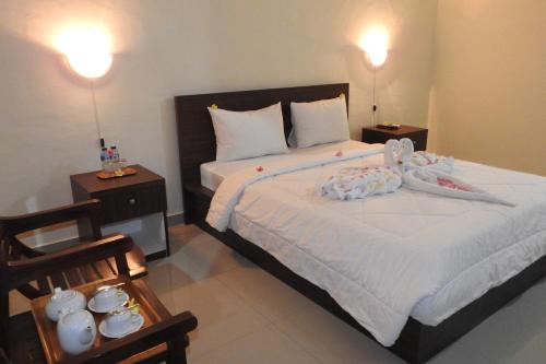 a bedroom with a bed with two night stands and two lamps at D'Batur Hotel in Senggigi 