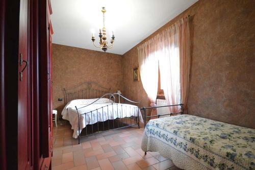 1 dormitorio con 2 camas y lámpara de araña en ristorantino il Sovrano BeB, en SantʼAnatolia di Narco