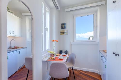 a white kitchen with a table and a window at Dousmani Corfu Old Town Studio Suite in Corfu Town