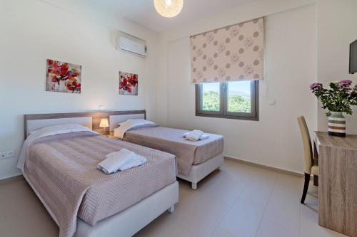 a bedroom with two beds and a table and a window at Chloe in Vederoi