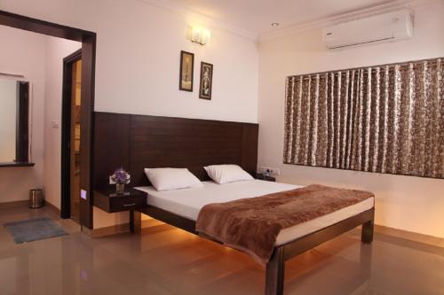 a bedroom with a bed and a large window at Vinay Residency in Sindhnūr