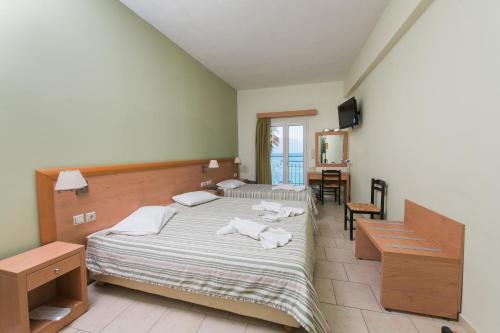 a bedroom with two beds with towels on them at Plaz Hotel in Selianitika