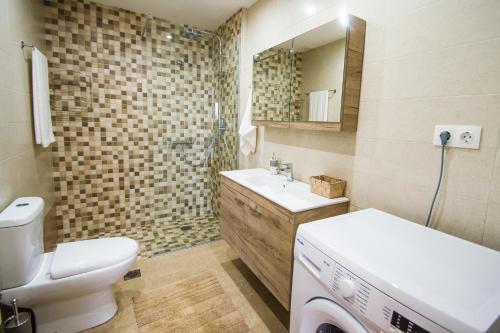 a bathroom with a sink and a washing machine at Souda Bay Loggia in Sellía