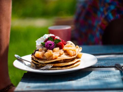 a plate of pancakes with fruit on a table at Namaste Hostel & Camping in Bar