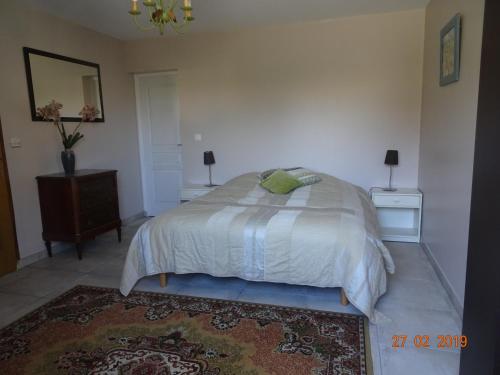 a bedroom with a bed and two night stands and a rug at LE PETIT MARAIS in Clais