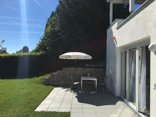 a table with an umbrella on a patio at Bodenseeapartments Kunst & Design in Immenstaad am Bodensee