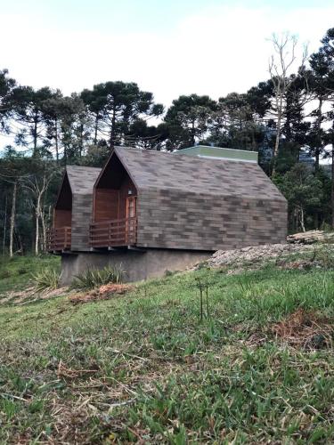 a house sitting on top of a grass field at Refúgio da Montanha in Urubici