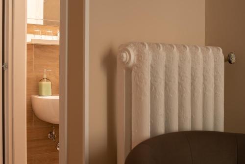 uma casa de banho com um radiador branco ao lado de um lavatório em Sogno di un'epoca em Roma
