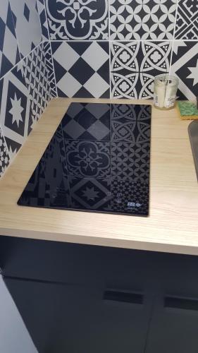 a wooden counter top with black and white tiles at charmant studio coeur centre ville in Avignon