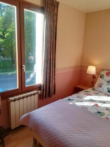 a bedroom with a bed and a window at Hotel La Croix des Bois in Lalizolle