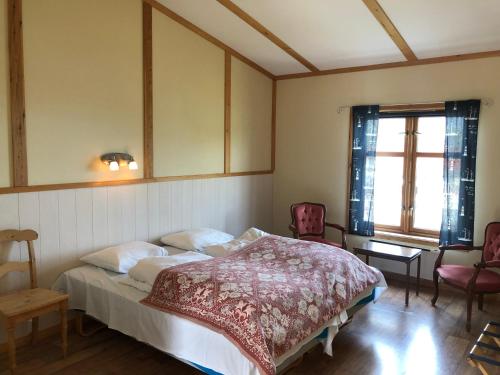 1 Schlafzimmer mit einem Bett, 2 Stühlen und einem Fenster in der Unterkunft Arran Nordkapp in Honningsvåg