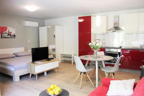 een woonkamer en een keuken met een bed en een tafel bij Apartmani Žužić in Poreč