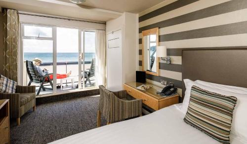 a hotel room with a bed and a view of the ocean at Golden Sands in St Brelade