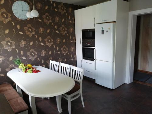 a kitchen with a white table and a white refrigerator at Mieszkania na wydmach in Dziwnów