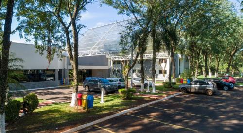 a parking lot with cars parked in front of a building at Hotel Nacional Inn Foz do Iguaçu in Foz do Iguaçu