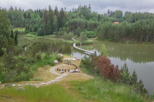 a pond with a fire pit in the middle of it at Dzeņi in Amatciems
